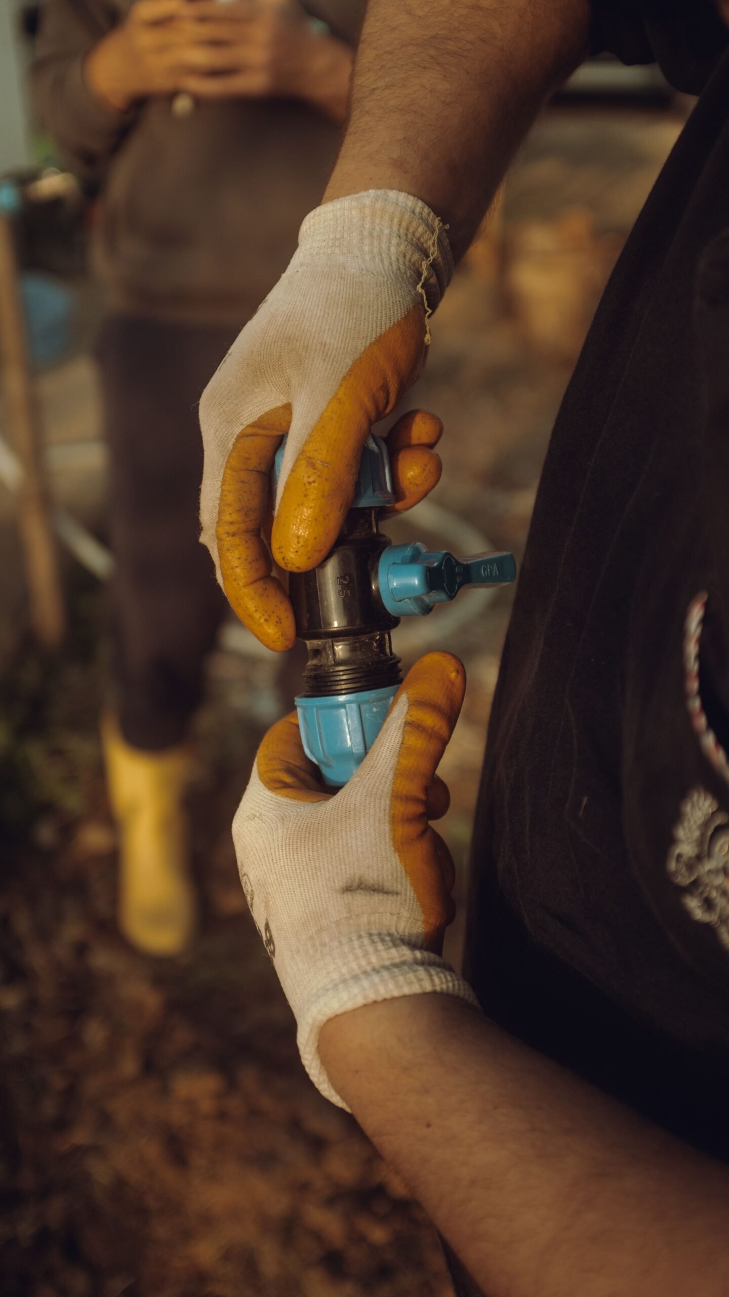 Plumber connecting a PEX pipe fitting outdoors, Los Angeles CA